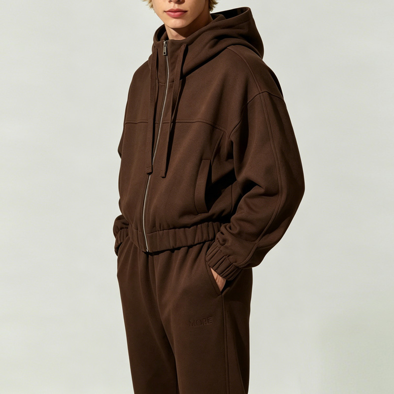 Side view of men's brown jogging suit, showing relaxed fit, ribbed cuffs, and deep pockets.