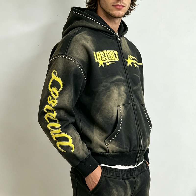 Side view of sun-faded washed black zip-up hoodie, showing sleeve script print and rhinestone detailing on the shoulders and pockets