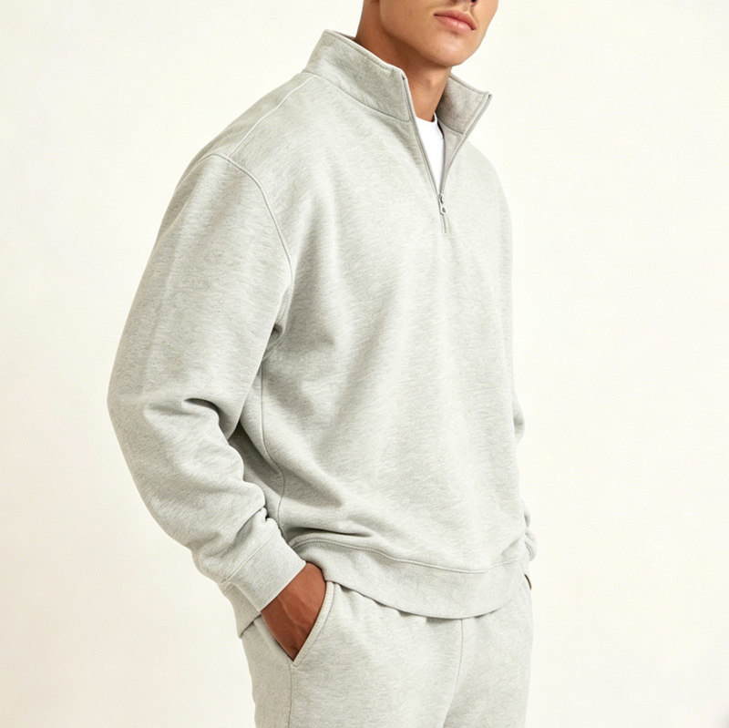 Side view of men's light gray half-zip sweatshirt, showing relaxed fit and clean silhouette